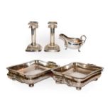 A pair of silver plated entree dishes, a pair of table candlesticks and a sauce boat