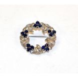 A sapphire and diamond brooch, realistically modelled as a wreath, clusters of three round cut