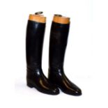 A pair of leather riding boots and wooden trees with brass pulls, trees stamped Green Street,