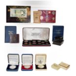 A box of assorted British coins and coin sets, including commemorative crowns, pre and post