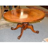 A Victorian figured walnut breakfast table with oval top, raised on four carved scrolling