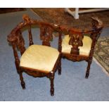 A reproduction carved mahogany conversation chair, with drop-in upholstered seats, ornamented with