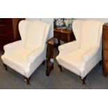 A pair of Georgian style wingback armchairs, raised on cabriole supports, upholstered white back