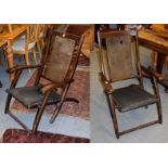 A pair of early 20th century teak and cane work folding steamer chairs