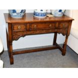 A Titchmarsh & Goodwin carved oak three drawer side table, with turned supports and H-stretcher,