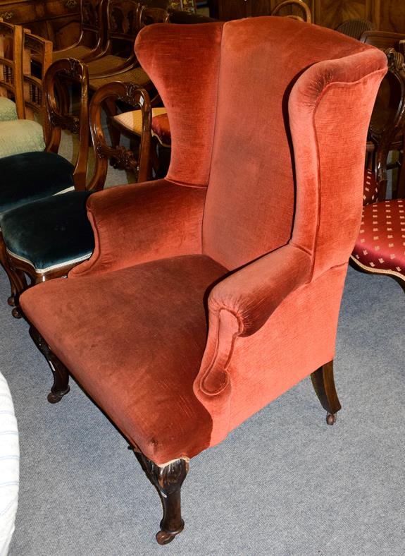 A 19th century carved walnut and upholstered wingback armchair