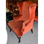 A 19th century carved walnut and upholstered wingback armchair