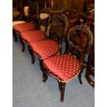 A set of four Victorian carved walnut salon chairs, raised on scroll supports