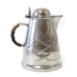 Liberty & Co: A Tudric Pewter Hot Water Jug, with a domed hinged cover, rattan covered handle,