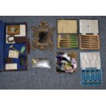 Assorted items including three cased flatware's, plated cigarette box, metal easel framed mirror,