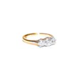 A diamond three stone ring, the graduated round brilliant cut diamonds in white claw settings, to
