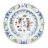 An English Delft plate, mid 18th century, painted in colours with a central flower spray within