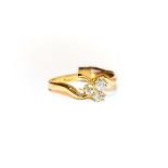 An 18 carat gold diamond three stone ring, the three old cut diamonds in a clover arrangement, in
