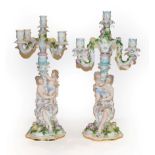 Two 19th century German porcelain figural five branch candelabra, decorated in coloured enamels,