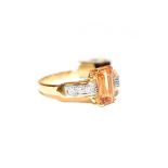 A topaz and diamond ring, the emerald-cut golden topaz in a yellow four claw setting, to an eight-