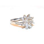 A diamond cluster ring, the raised central round brilliant cut diamond within a double border of