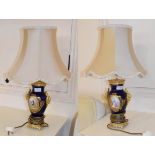 A pair of gilt metal and painted porcelain vase form table lamps, each with rams mask handles and