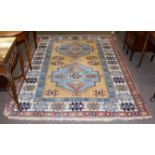 A polychrome carpet with a central blue ground medallion, 242cm by 184cm