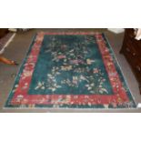 Chinese Art Deco rug, the emerald green field with a plant in flower enclosed by meandering vine