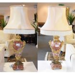 A pair of gilt metal mounted rouge marble table lamps with satyr mask handles and floral swags, each
