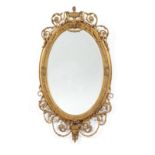 A Gilt and Gesso Oval Mirror, in Adam style, the oval bevelled glass plate within a moulded stiff