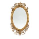 A Victorian Gilt and Gesso Oval Mirror, in Adam style, the oval bevelled glass plate within a