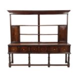 An Early 18th Century Open Dresser and Rack, with three fixed shelves above two cupboard doors,