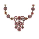 A Garnet and Red Stone Necklace, the central panel formed of a bow motif suspends a scroll motif