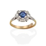 A Sapphire and Diamond Cluster Ring, the oval cut sapphire within an undulating border of eight-