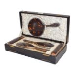 A cased five-piece silver and tortoiseshell mounted brush set