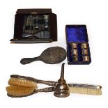 Four various silver backed dressing table items, a gent's leather travelling vanity case