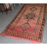 Kurdish rug the field of terracotta enclosed by triple borders, 226cm by 124cm