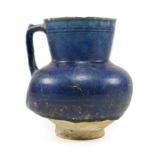 An Iranian Blue Glazed Ewer, 12th/13th century, of ovoid form with angular handle, the slightly