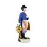 A Gardner Porcelain Figure of a Sbiten Vendor, early 19th century, standing wearing a black top hat,