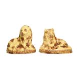 A Pair of Buff Glazed Earthenware Figures of Lions, circa 1800, recumbent, on oval bases with