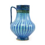 A Kashan Pottery Ewer, 13th century, of baluster form with strap handle, painted in black with