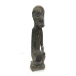 A 20th Century Dyak Ironwood Ancestor Figure, Borneo, squatting with elongated body and arms, his