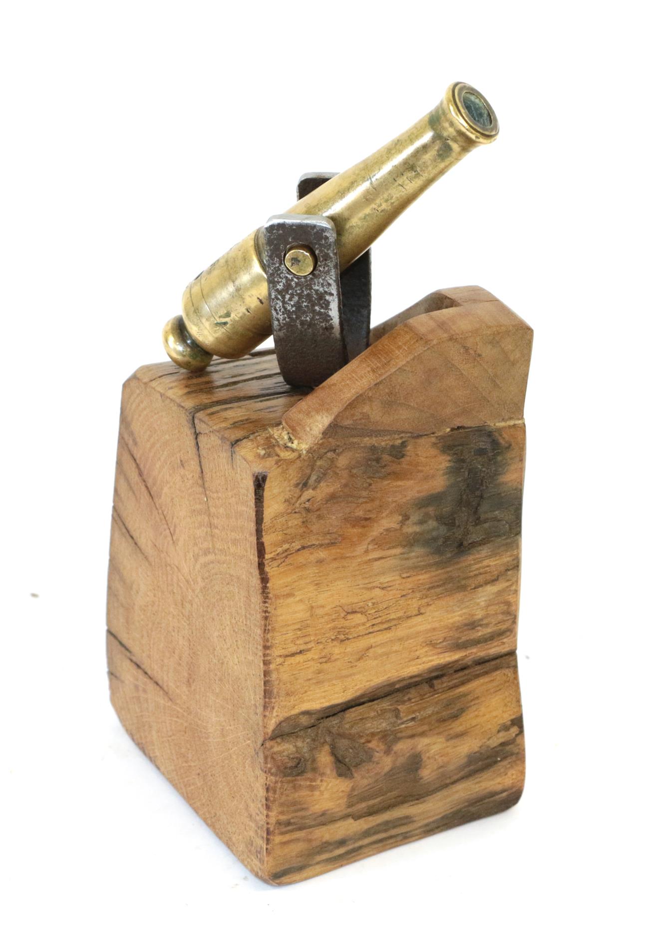 A Small Brass Desk Cannon, the 11cm barrel stamped with broad arrow/V R and mounted on an oak block,