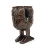 A 20th Century Kuba Janus Head Palm Wine Cup, each head with incised diaper coiffure, shaped face