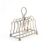 An Edward VII Silver Toast rack, by William Aitken, Birmingham, 1902, oblong and on four ball