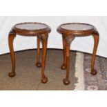 A pair of early 20th century carved mahogany plant stands, raised on carved cabriole supports