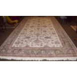 A large machine made carpet of oriental design, the cream field with an all over design of palmettes