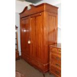 A large 20th century Continental walnut double wardrobe with arched pediment and two-drawer base,