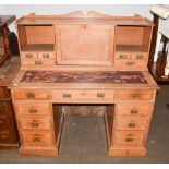 An early 20th century light oak twin-pedestal leather topped desk with raised super structure, 122cm