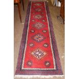 A Caucasian design runner, the blood red field with a column of latch hook guls enclosed by barber