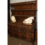 A 20th century priory style carved oak dresser and rack, 137cm by 42cm by 117cm