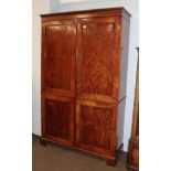 A Victorian figured mahogany double wardrobe with panelled doors, raised on bracket feet, 129cm by