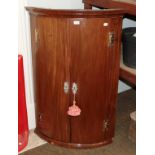 A George III mahogany bow-fronted handing corner cupboard, 75cm by 51cm by 112cm
