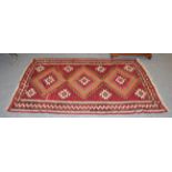 A Kilim rug polychrome with three central lozenges, 240cm by 145cm. Colour has run in some areas.