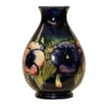 A Moorcroft Pansies pattern vase, blue ground, painted and impressed marks, 25cm. Crazed and with
